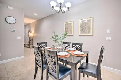 a dining room with a table and chairs and a clock at Private Pool and Lanai Resort Townhome in Kissimmee in Kissimmee