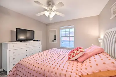 a bedroom with a bed with a ceiling fan and a tv at Private Pool and Lanai Resort Townhome in Kissimmee in Kissimmee