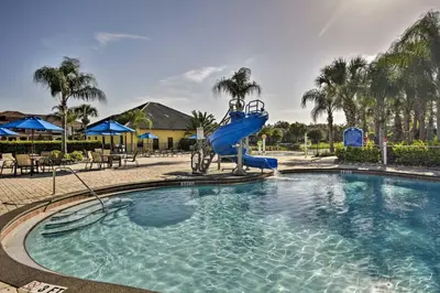 a swimming pool with a slide in a resort at Private Pool and Lanai Resort Townhome in Kissimmee in Kissimmee