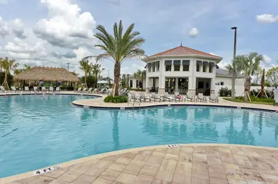 a large swimming pool with chairs and a building at 4721 Unit 105 BRAND NEW stunning apartment in Kissimmee