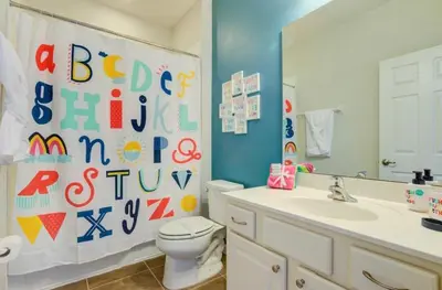 a bathroom with a toilet and a sink and a mirror at 6BR Resort Villa Near Disney Private Pool 2584 in Kissimmee