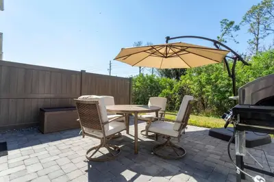 a patio with a table and chairs and an umbrella at Mickey Safari near Disney 2 Master rooms 4708 in Kissimmee
