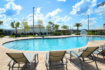 a large pool with chairs and a fountain at Modern Condo with Lake View Near Disney 3151 in Kissimmee