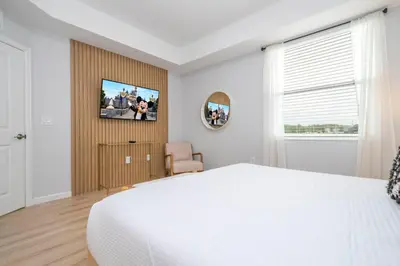 a bedroom with a white bed and a tv on a wall at Modern Resort FREE Waterpark Near Disney 3171 in Kissimmee