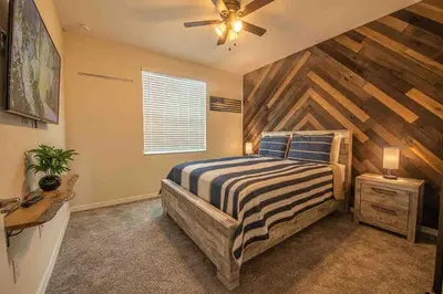 a bedroom with a bed and a wooden wall at Resort Condo Near Disney FREE Waterpark 3120 in Kissimmee