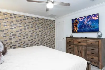 a bedroom with a bed and a tv on a wall at FREE Waterpark 4BR Marvel Superhero-Themed 2967 in Kissimmee