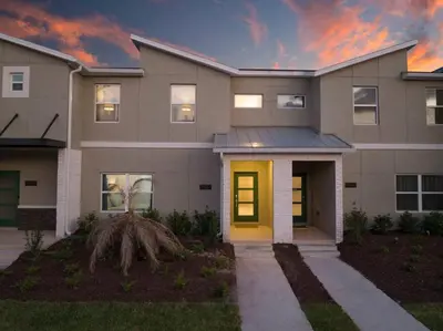 a house with a yellow door at dusk at FREE Waterpark 4BR Marvel Superhero-Themed 2967 in Kissimmee