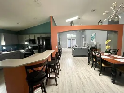 a kitchen and living room with a table and chairs at Luxury Disney Family Villa (5-Bedroom, pool & spa) in Kissimmee