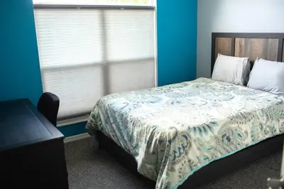 a blue bedroom with a bed and a window at Luxury Disney Family Villa (5-Bedroom, pool & spa) in Kissimmee