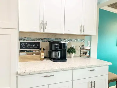a kitchen with white cabinets and a coffee maker on a counter at FUN! PoolLake near Disney Fast WiFi Pickleball in Clermont