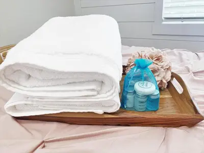 a tray with towels and a bottle of detergent on a bed at FUN! PoolLake near Disney Fast WiFi Pickleball in Clermont