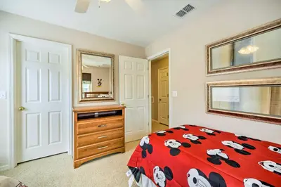 a bedroom with a bed and a dresser and a mirror at Kissimmee Getaway about 4 Mi to Walt Disney World in Kissimmee