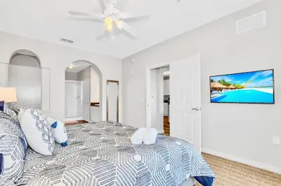a white bedroom with a bed and a ceiling fan at Spacious 3BR Condo with Pool near Disney in Orlando