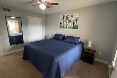 a bedroom with a blue bed and a ceiling fan at very Nice 2/2 apartment , close to disney in Kissimmee