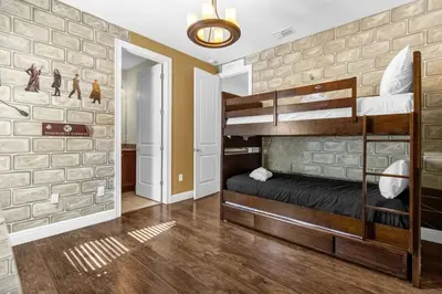 a bedroom with two bunk beds and a brick wall at 7601-IBRAHIM · 7601 Themed 7BD Villa- Poolspa - Game room in Orlando