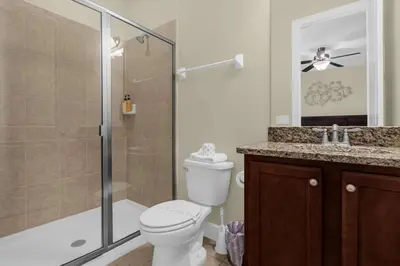 a bathroom with a toilet and a shower and a sink at 7601-IBRAHIM · 7601 Themed 7BD Villa- Poolspa - Game room in Orlando