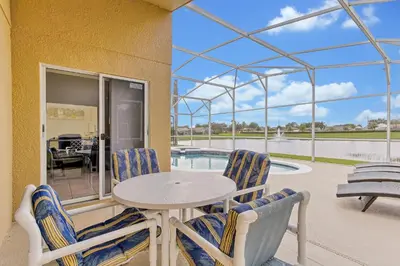 a patio with a table and chairs and a pool at Star Lake Oasis - 4 bed family pool home in Orlando