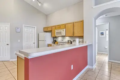 a kitchen with a large counter top and wooden cabinets at Star Lake Oasis - 4 bed family pool home in Orlando