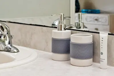 a bathroom counter with two cups and a sink at Star Lake Oasis - 4 bed family pool home in Orlando