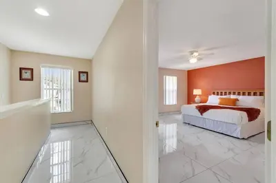 a bedroom with a bed and an orange wall at South Facing Pool, Close to Attractions, Remodeled in Kissimmee
