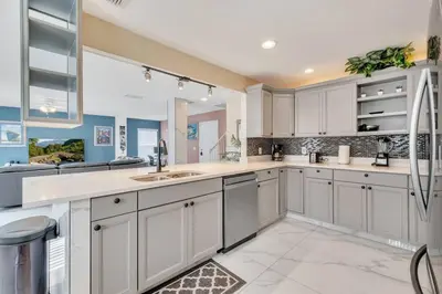 a kitchen with white cabinets and a large window at South Facing Pool, Close to Attractions, Remodeled in Kissimmee