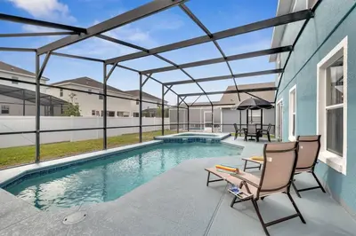 a swimming pool with a pergola next to a house at South Facing Pool, Close to Attractions, Remodeled in Kissimmee
