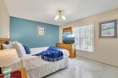 a bedroom with a bed with a blue wall at South Facing Pool, Close to Attractions, Remodeled in Kissimmee