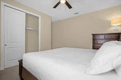 a bedroom with a white bed and a ceiling fan at GREAT HOUSE Near Disney, Private Pool in Orlando