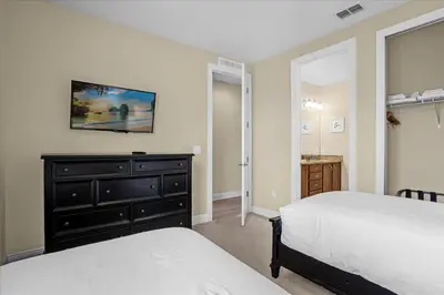 a bedroom with a bed and a dresser with a mirror at GREAT HOUSE Near Disney, Private Pool in Orlando