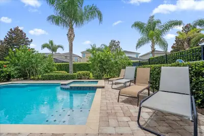 a pool with two chairs and palm trees at GREAT HOUSE Near Disney, Private Pool in Orlando