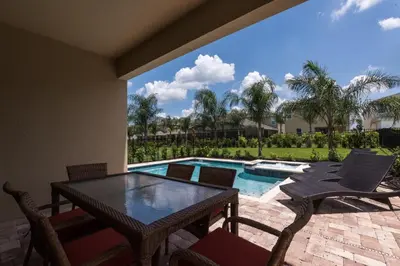 a patio with a table and chairs and a swimming pool at GREAT HOUSE Near Disney, Private Pool in Orlando
