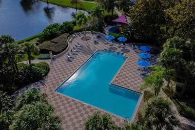 an overhead view of a swimming pool with chairs and umbrellas at Welcome to Villa Azul, your home away from home! in Kissimmee
