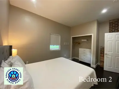 a bedroom with a large white bed in a room at The Front Porch in Sanford