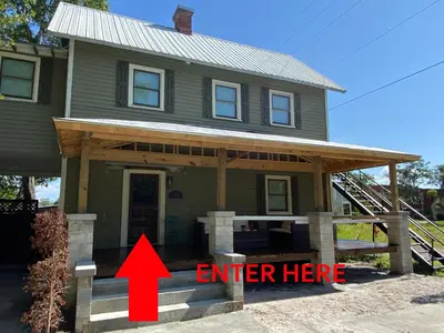 a house with a red arrow pointing to an enter here at The Front Porch in Sanford