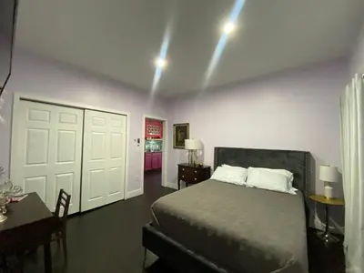 a bedroom with a bed and a table and a door at Boho Nights in Sanford