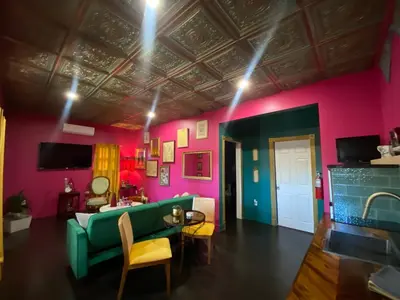 a living room with a green couch and pink walls at Boho Nights in Sanford