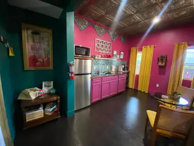 a kitchen with pink and green walls and a refrigerator at Boho Nights in Sanford