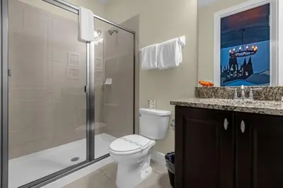 a bathroom with a toilet and a shower and a sink at 431 Villa - Spacious 7BD - Screened PoolSPA in Orlando