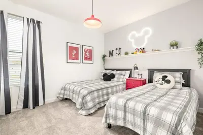 two beds in a bedroom with white walls at Luxury home, private pool, themed bedrooms, prime location in Kissimmee