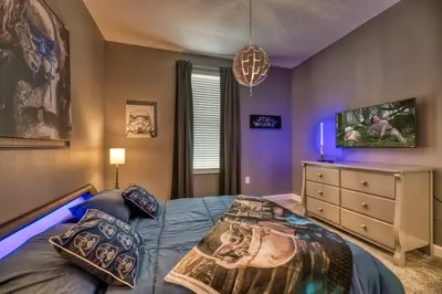 a bedroom with a bed and a dresser at Luxury home, private pool, themed bedrooms, prime location in Kissimmee