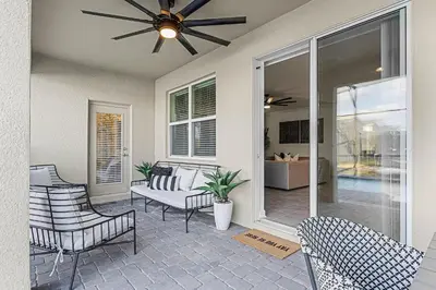 a porch with chairs and a ceiling fan at Disney Dream Vacation Home by Disney in Kissimmee
