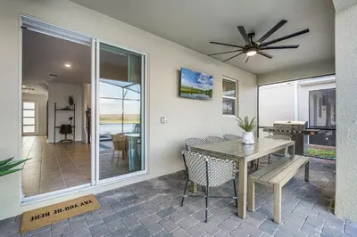 a dining room with a table and a ceiling fan at Disney Dream Vacation Home by Disney in Kissimmee