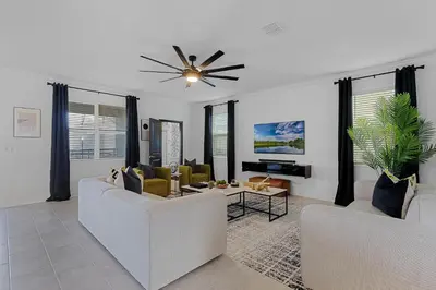 a living room with two couches and a ceiling fan at Disney Dream Vacation Home by Disney in Kissimmee