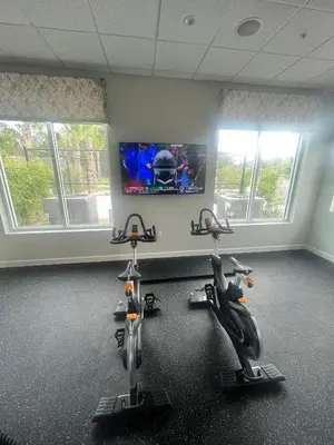 a gym with two exercise bikes and a flat screen tv at Disney Dream Vacation Home by Disney in Kissimmee