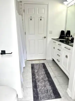 a bathroom with a white door and a rug on the floor at Dreamy Family Pool House in Clermont
