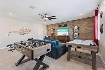 a living room with a couch and a ping pong table at Water Kingdom Storey Lake By Shine Villas #525 in Kissimmee