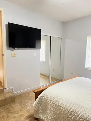 a bedroom with a bed and a flat screen tv on the wall at Spacious and relaxing Home - Longwood, Florida in Orlando