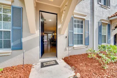 a front door of a house with blue shutters at 15 Mi to Disney Kissimmee Townhome with Patio in Kissimmee