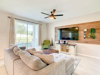a living room with a couch and a flat screen tv at Wonderful 2BR Condo with 2 Clubhouses in Kissimmee
