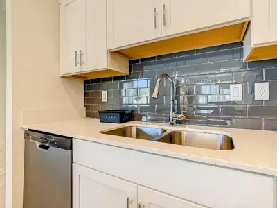 a kitchen with a stainless steel sink and white cabinets at Wonderful 2BR Condo with 2 Clubhouses in Kissimmee